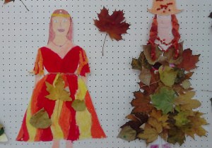 Na zdjęciu widać dwie sylwetki przedstawiające Panią Jesień. Postać po lewo ozdobiona: kredkami, bibułą, liśćmi. Postać po prawo ozdobiona: kredkami, bibułą, liśćmi, koralami jarzębiny.